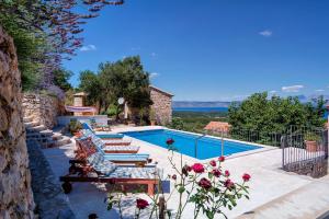 a swimming pool with chaise lounge chairs and a swimming pool at Stone Villa Marjan in Pitve