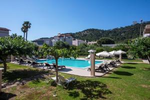 a swimming pool with lounge chairs and umbrellas at Santa Helena Hotel in Ialysos