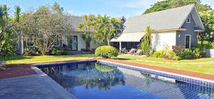 a house with a swimming pool in front of a house at 90 9 Pool Villa Chiang Mai in Ban Pa Ngae