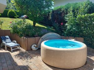 a large hot tub in a yard with a chair at Ferienwohnung Gartentraum in Oberzent