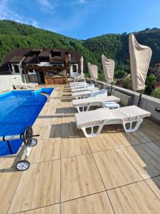 a row of lounge chairs on the roof of a resort at Apartmani Sunce Stara planina in Crni Vrh