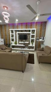 ein Wohnzimmer mit zwei Sofas und einem Fernseher in der Unterkunft Sackoappartements in Bamako + 13 Fotos