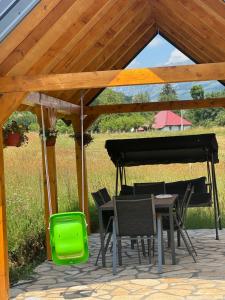 a table and chairs and a piano under a pavilion at Forest View Kolašin in Kolašin