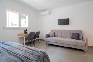 a bedroom with a couch and a table and a desk at Marghera Venice Link Rooms in Venice