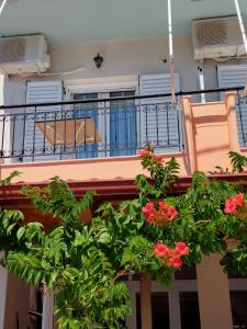 a balcony with a chair and flowers on it at ΠΗΛΙΟΣ ΦΩΤΙΟΣ in Loutsa