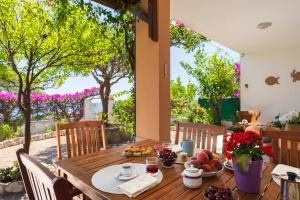 a wooden table with food and wine on a patio at Sos Dorroles Motoparking in Cala Gonone