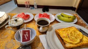a table topped with plates of breakfast food and fruit at Warna Cottage in Gili Trawangan +12 photos