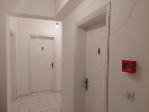 a hallway with two white doors and a tile floor at ΠΗΛΙΟΣ ΦΩΤΙΟΣ in Loutsa