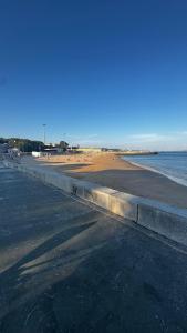an empty beach with the ocean and a road at Casa Nautica in Paço de Arcos