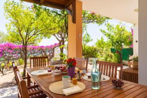 a wooden table on a patio with flowers on it at Sos Dorroles Motoparking in Cala Gonone