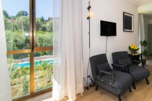 a room with two chairs and a window at Casa di Giò Apartment, Pool, 200m from Lake Garda in Gardone Riviera