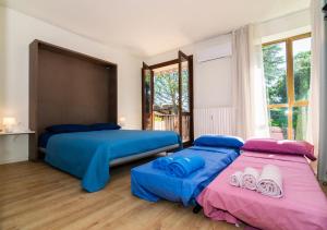 two beds in a room with blue and pink at Casa di Giò Apartment, Pool, 200m from Lake Garda in Gardone Riviera +26 photos