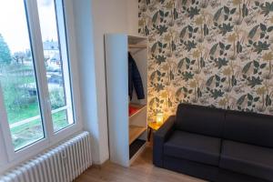 a living room with a couch and a mirror at Studio LEntre Nous in Saint-Pierre-de-Chartreuse