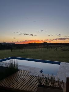a swimming pool with a sunset in the background at Sierras de Canela premium in Tandil