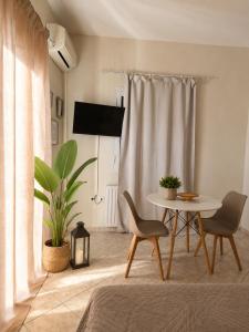 a living room with a table and chairs and a plant at Rouchotas Studios by Viktor 1rst Floor in Argostoli