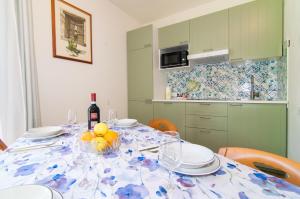 a table with a bowl of fruit and a bottle of wine at Casa di Giò Apartment, Pool, 200m from Lake Garda in Gardone Riviera