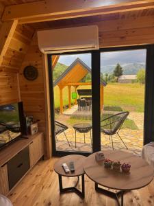 a living room with a large window in a cabin at Forest View Kolašin in Kolašin