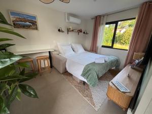 a bedroom with a bed and a desk and a window at Résidence les 3 volcans 4 étoiles in Clermont-Ferrand