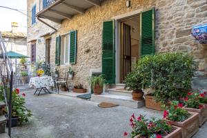 a house with green shutters and a table with plants at Pietro Guest House in Cortona