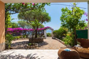 a patio with a garden with flowers and trees at Sos Dorroles Motoparking in Cala Gonone