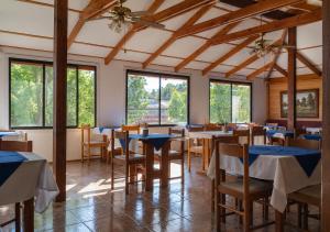a dining room with tables and chairs and windows at Hotel Carande, Papudo in Papudo