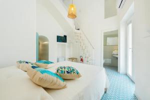 a white bedroom with a bed with pillows on it at Stella di Mare in Procida