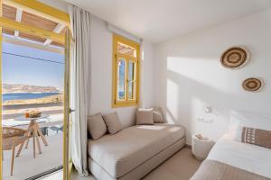 a bedroom with a couch and a view of the ocean at Asterry Suites in Kimolos