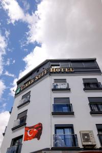 a white building with a sign for a hotel at Çınar Suit Hotel in Buca