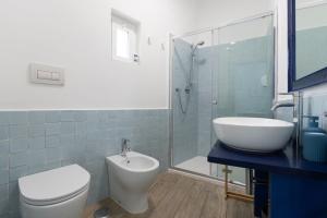 a bathroom with a toilet and a sink and a shower at Molo '93 - RoomsAndSea in Belvedere Marittimo