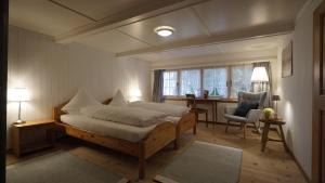 a bedroom with a bed and a desk and a chair at Ferienhotel Idyll Gais in Gais