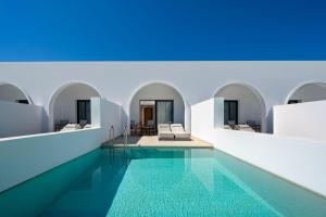 a swimming pool in a building with blue ceilings at Neya Elements in Lartos