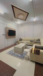 a living room with couches and a flat screen tv at شقق مخدومه in Najran