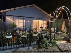 a group of people sitting at tables in a greenhouse at The Blue Cottage in Dimapur