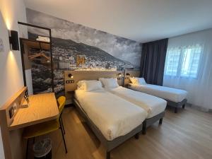 a hotel room with two beds and a painting on the wall at B&B HOTEL Bastia in Bastia