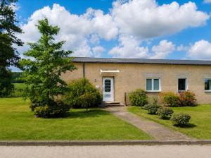 a brick house with a tree in the yard at Pension Greifswald in Dargelin