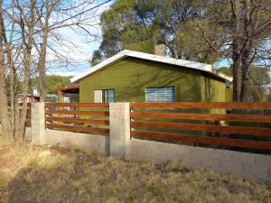 a fence in front of a small green building at El Rancho Oliva in Molinari