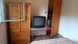 a small television sitting on a table in a bedroom at El Rancho Oliva in Molinari +8 photos
