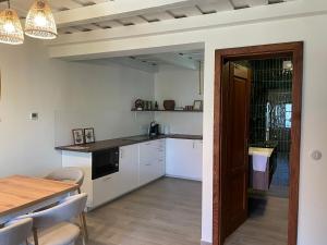 a kitchen with white cabinets and a table and a dining room at Vanellus in Balatongyörök