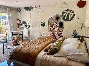 ein Schlafzimmer mit einem Bett und Pflanzen an der Wand in der Unterkunft Ker Amice , une parenthèse de calme près de Bordeaux , 3 chambres avec Spa Privatif in Saint-Loubès