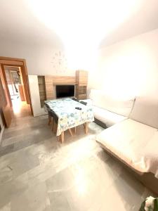 a living room with a table and a couch at Piso en Barbate 2 dormitorios y piscina comunitaria in Barbate