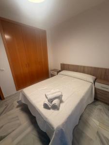 a bedroom with a bed with two pairs of shoes on it at Piso en Barbate 2 dormitorios y piscina comunitaria in Barbate