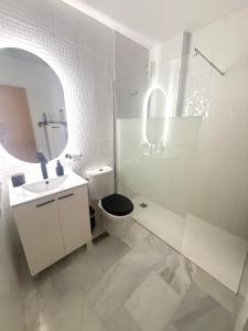 a bathroom with a toilet and a sink and a mirror at Piso en Barbate 2 dormitorios y piscina comunitaria in Barbate