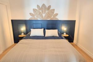 a bedroom with a large bed with two lamps at Le Saphir in Poligny +7 photos