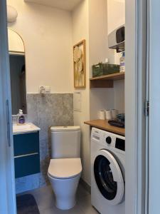 a bathroom with a toilet and a washing machine at Apartament centrum Szczytno Mazury in Szczytno