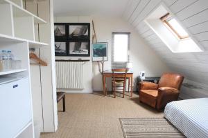 a attic room with a bed and a chair and a table at Chambre d'hôtes Ouest Laurent Vidal in Plouharnel +24 photos