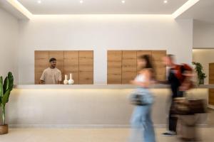 a group of people walking past a counter in a restaurant at Neya Elements in Lartos +31 photos