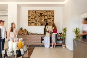 two women standing in a living room preparing food at Neya Elements in Lartos