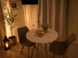 a table with two chairs and a table and a lamp at Rouchotas Studios by Viktor 1rst Floor in Argostoli