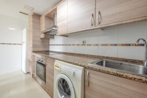 a kitchen with a washing machine and a sink at Planta baja Marita in Deltebre