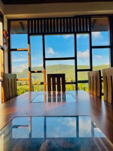 a dining room table with chairs and a large window at travellers nest inn in Nuwara Eliya +41 photos